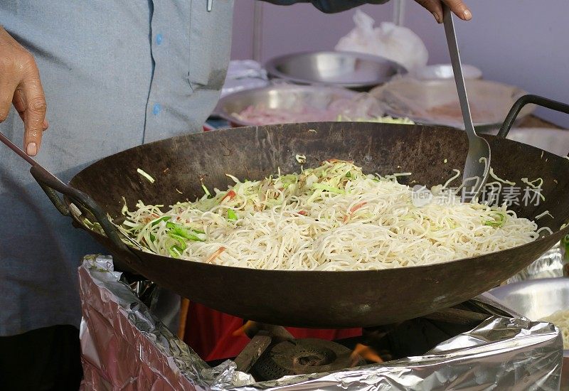 印度/中国街头食物在锅里烹饪，健康的新加坡面条/炒面与辣椒和洋葱一起炒，在煤气炉上烹饪